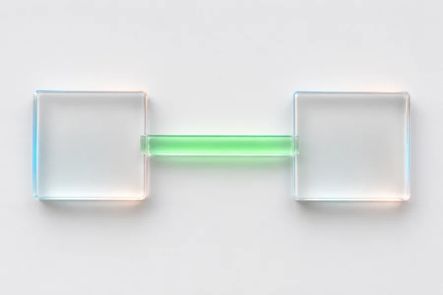 Dos bloques de vidrio unidos por un puente iluminado